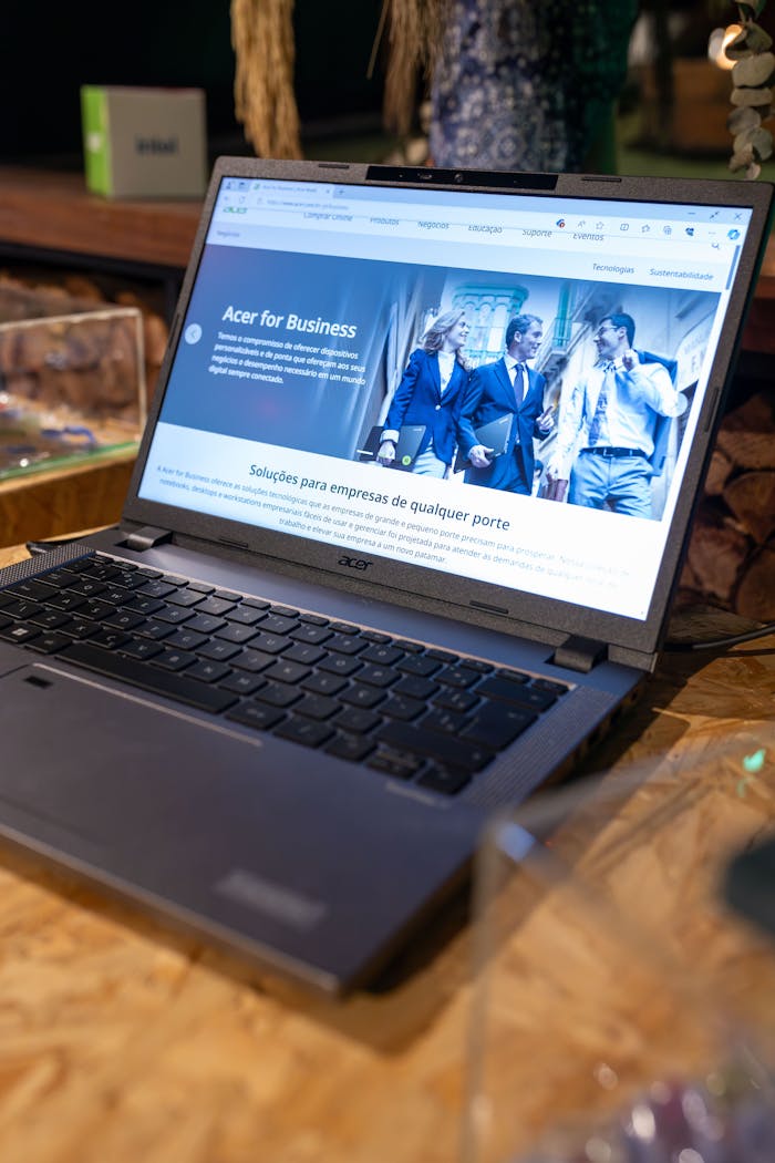 A laptop computer on a wooden table with a screen